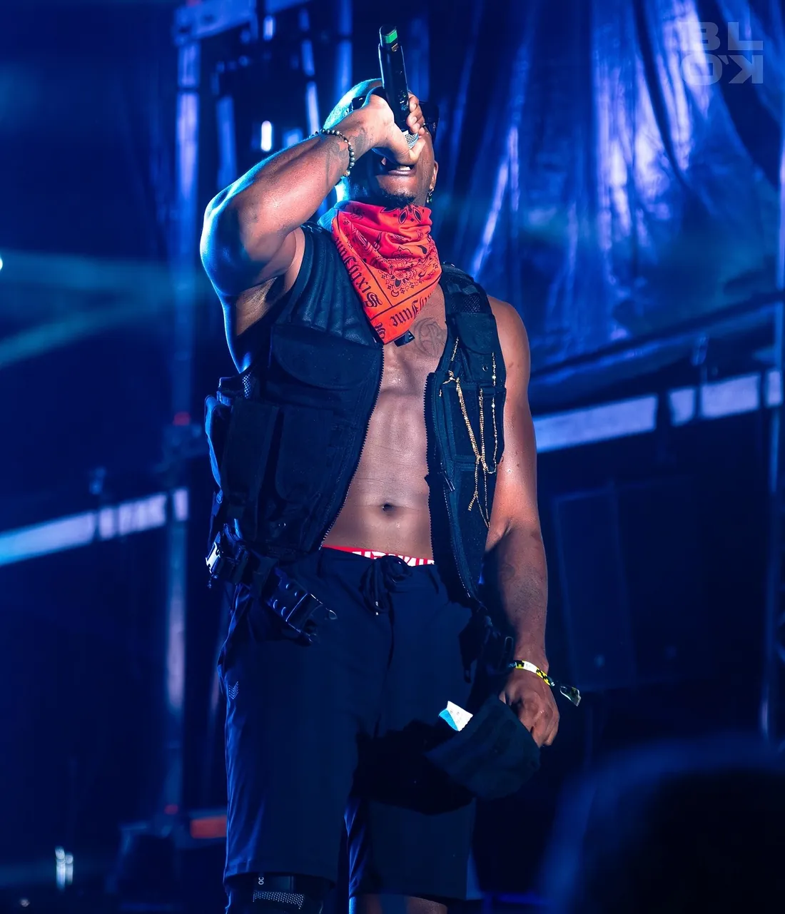 Artiste au bandana rouge, micro devant la foule
