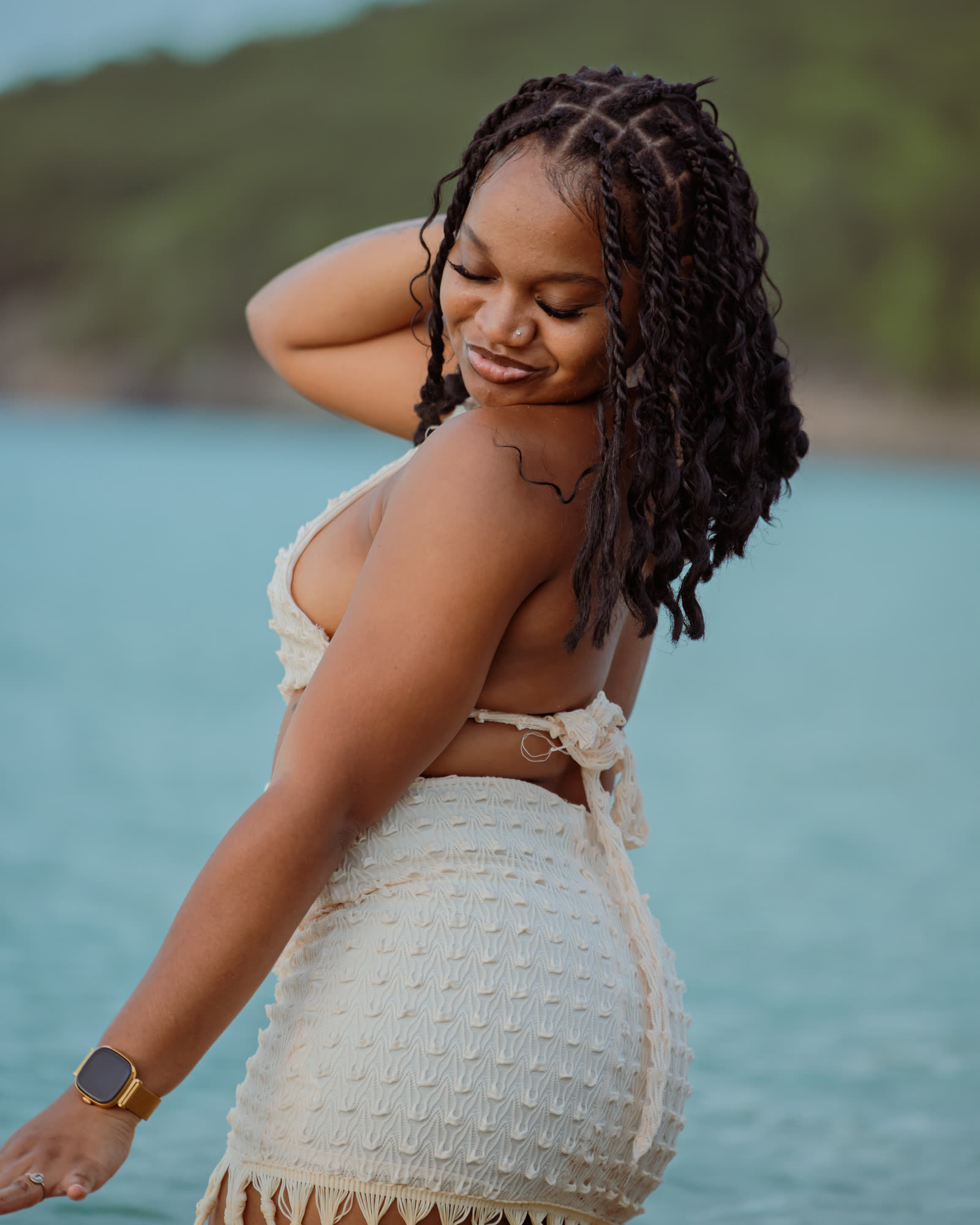 Loana de trois quarts, un bras derrière la tête, sourire